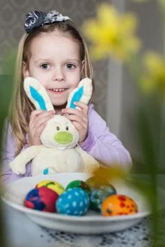 Smiling cute child with easter eggs and plush bunny. Easter, holiday Stock Photos