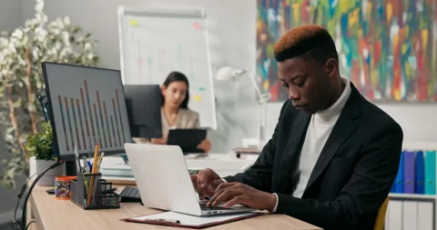 A smiling dark-skinned boy spends morning at work in front of computer screen Stock Footage 163859757
