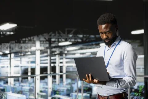 Smiling data center engineer on industrial platform works on neural network Fotos Stock