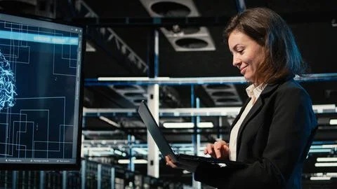 Smiling data center female engineer pleased after upgrading AI systems Stock Photos