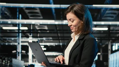 Smiling data center female engineer pleased after upgrading AI systems Stock Photos