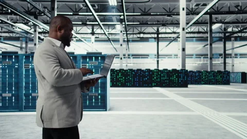 Smiling data center programmer using laptop to upgrade system stability Stock Footage 311833519