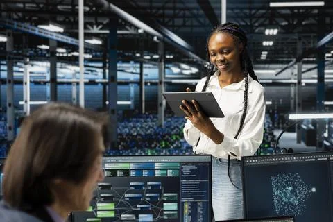 Smiling data center software developer using tablet, coding, managing systems Foto stock