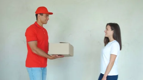 Smiling delivery man delivering parcel to a woman Video stock 112759890