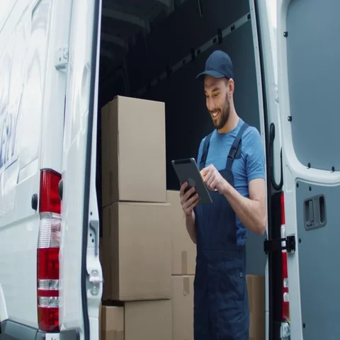Smiling Delivery Man with a Tablet Checks His Cargo Count. Stock Footage 69722969