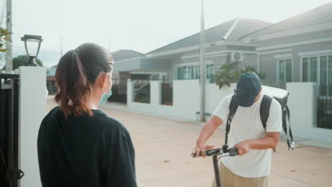 Smiling delivery man with thermal backpack riding on an electric scooter, del Vídeo Stock 202204492