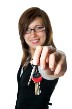 Smiling developer gives keys to new home. isolated on white background Stock Photos