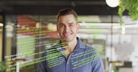 Smiling developer wearing blue shirt presenting code overlay at modern worksp Stockfoto's