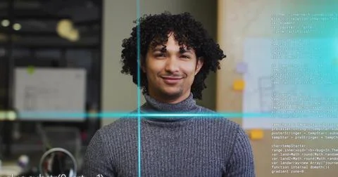 Smiling developer wearing grey sweater at office cubicle, with computer monit Stock Photos