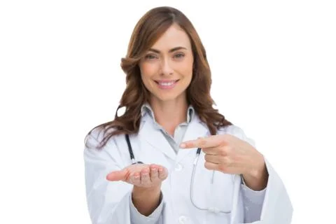 Smiling doctor pointing at something in her hand Stock Photos