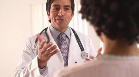 Smiling doctor talking to female patient Stock Footage