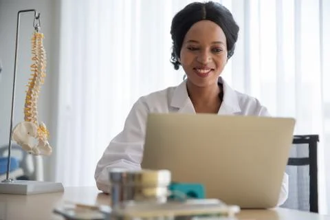 Smiling Doctor Using Laptop On Table Stock Photos