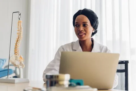 Smiling Doctor Using Laptop On Table Stock Photos