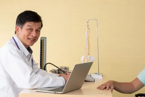 Smiling Doctor Using Laptop On Table Stock Photos