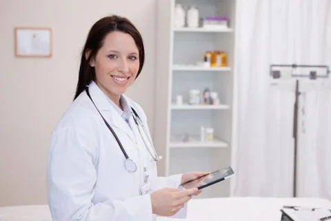 Smiling doctor using a tablet computer 스톡 사진