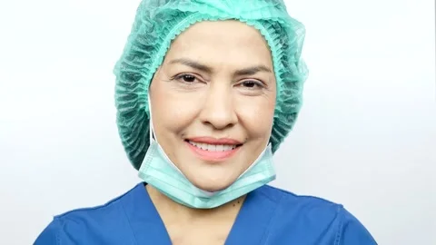 Smiling doctors and nurses looking at camera, she is properly covering face mask Stock Footage 244215997