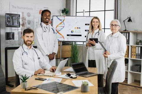 Smiling doctors looking at camera during conference indoor 스톡 사진