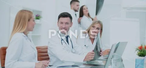 Smiling doctors working at office desk and smiling at camera, me Stock Photos