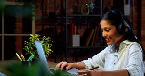 Smiling during video call, Indian businesswoman attends meeting using laptop Stock-Footage 342573566