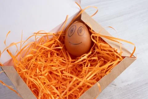 Smiling egg in a cardboard box. Stock Photos