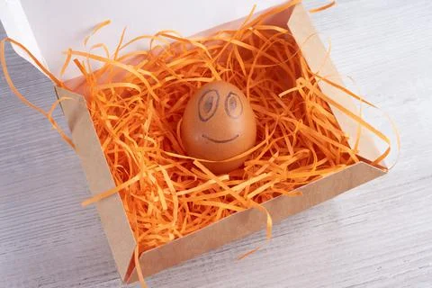 Smiling egg in a cardboard box. Stock Photos
