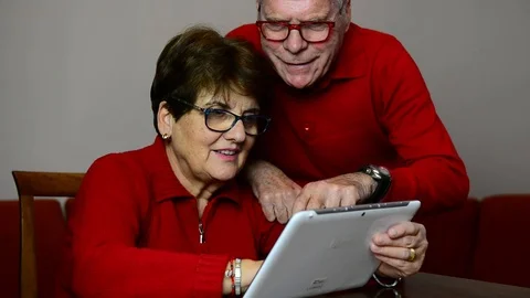Smiling elder caucasian couple using together a tablet 스톡 동영상 122972384