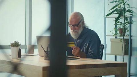 Smiling Elder Man Working Online with Laptop Computer and Using Credit Card Stock Footage 196251829
