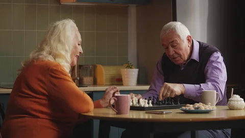 Smiling elderly couple playing chess at home, enjoying favorite hobby Stock Footage 337652524