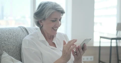 Smiling elderly lady using smartphone application to read positive new Stock Footage 159166470