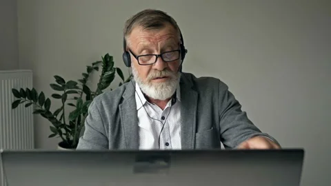 Smiling elderly man employee talk speak engaged in online conference using Stock Footage 140005428