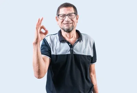 Smiling elderly man gesturing OK isolated. Cheerful old man gesturing appro.. Stock Photos