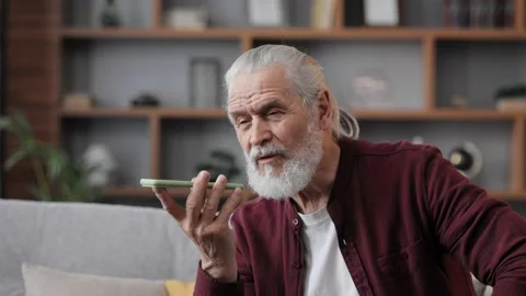 Smiling elderly man recording voice message on smartphone. Handsome senior man Stock Footage 197140248