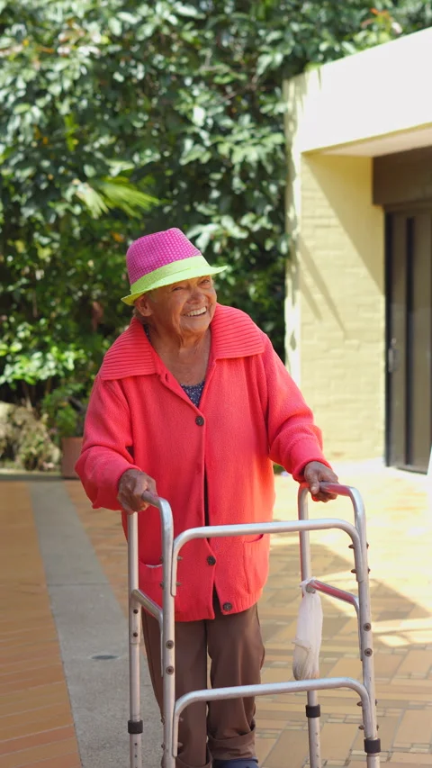 Smiling elderly woman using a walker for mobility, showcasing senior active. Stock Footage 283671703