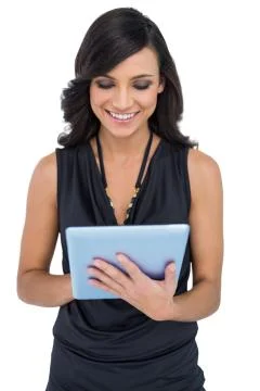 Smiling elegant brown haired model typing on tablet Stock Photos
