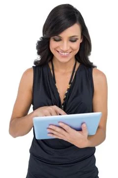Smiling elegant brown haired model scrolling on tablet Stock Photos