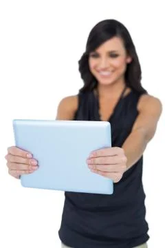 Smiling elegant brown haired model looking at her tablet pc Stock Photos