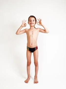 Smiling elementary 7 year olds boy thumbs up over white Stock Photos