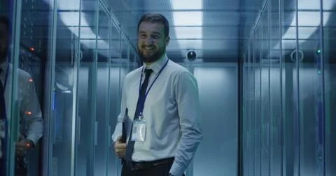 Smiling engineer in corridor of data center Foto stock