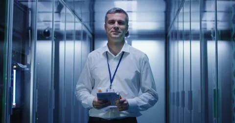 Smiling engineer in corridor of data center Foto stock