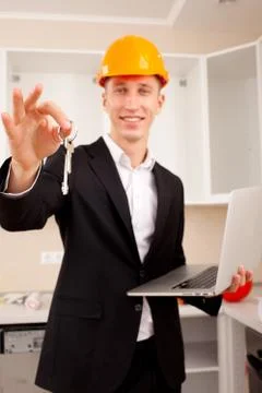 Smiling engineer gives keys Stock Photos