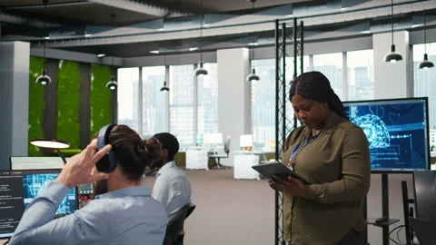 Smiling engineer next to office coworkers developing AI software applications Video stock 313014761