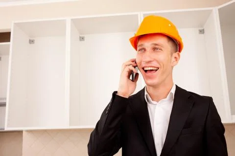 Smiling engineer talking on the phone in the interior Foto stock