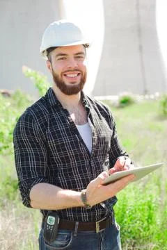 Smiling engineer using a tablet in a facility. Stock Photos