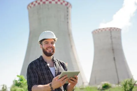 Smiling engineer using a tablet in a facility. Stock Photos
