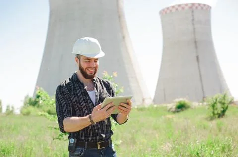Smiling engineer using a tablet in a facility. Stock Photos