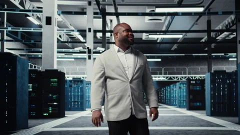 Smiling engineer walking in data center, checking hardware for system stability Stock Footage 311833463
