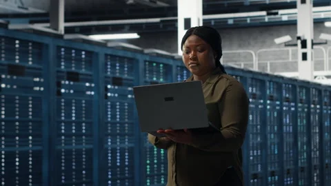 Smiling engineer walking in data center with laptop, checking hardware Stock Footage 317205173