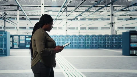 Smiling engineer walking in data center with laptop, checking hardware Stock Footage 317207265