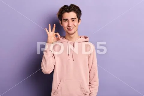Smiling excited handsome man showing OK sign Stock Photos