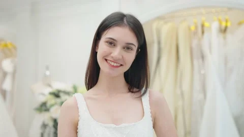 Smiling face of bride in white wedding dress looking at camera at wedding studio Stock Footage 231743744